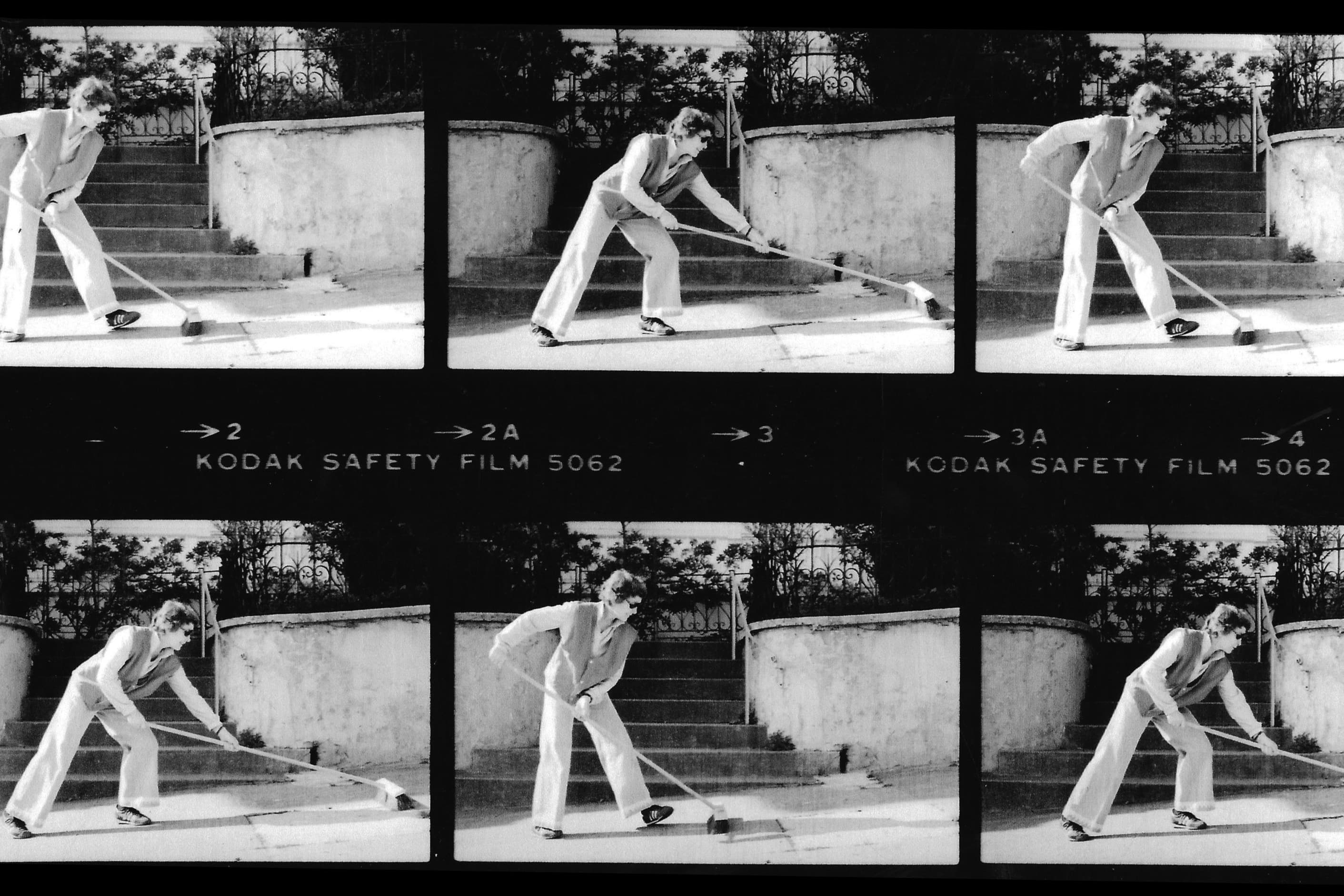 Black-and-white film contact sheet showing six sequential images of Jo Hanson sweeping the sidewalk in front of her Lower Haight home in San Francisco. Hanson transformed this everyday act into a public art practice and community anti-litter campaign that later inspired her creation of the Recology Artist in Residence (AIR) Program.