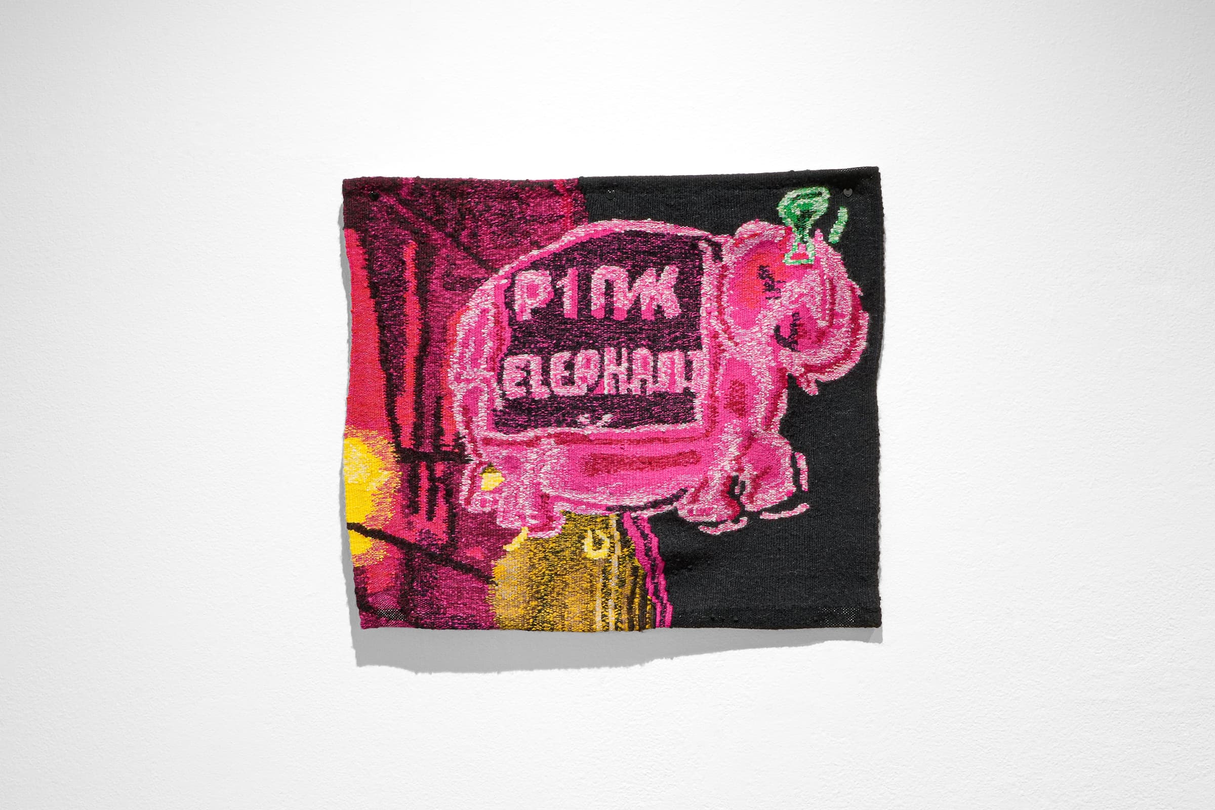 A three-dimensional tapestry featuring a neon pink elephant with a green martini glass on its head, with the body of the elephant reading ‘pink elephant.’