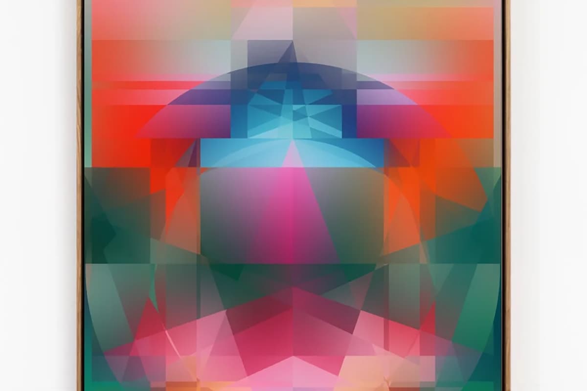 Tall vertical painting in a slim natural wood frame on a white wall. Layers of translucent triangles, blocks and a wide arc build a glowing symmetrical form: a blue dome near the top, magenta and pink triangles at center, deep green and orange along the sides, with a soft blue-green gradient band across the bottom. The overlapping shapes suggest a seated figure haloed by an arch.