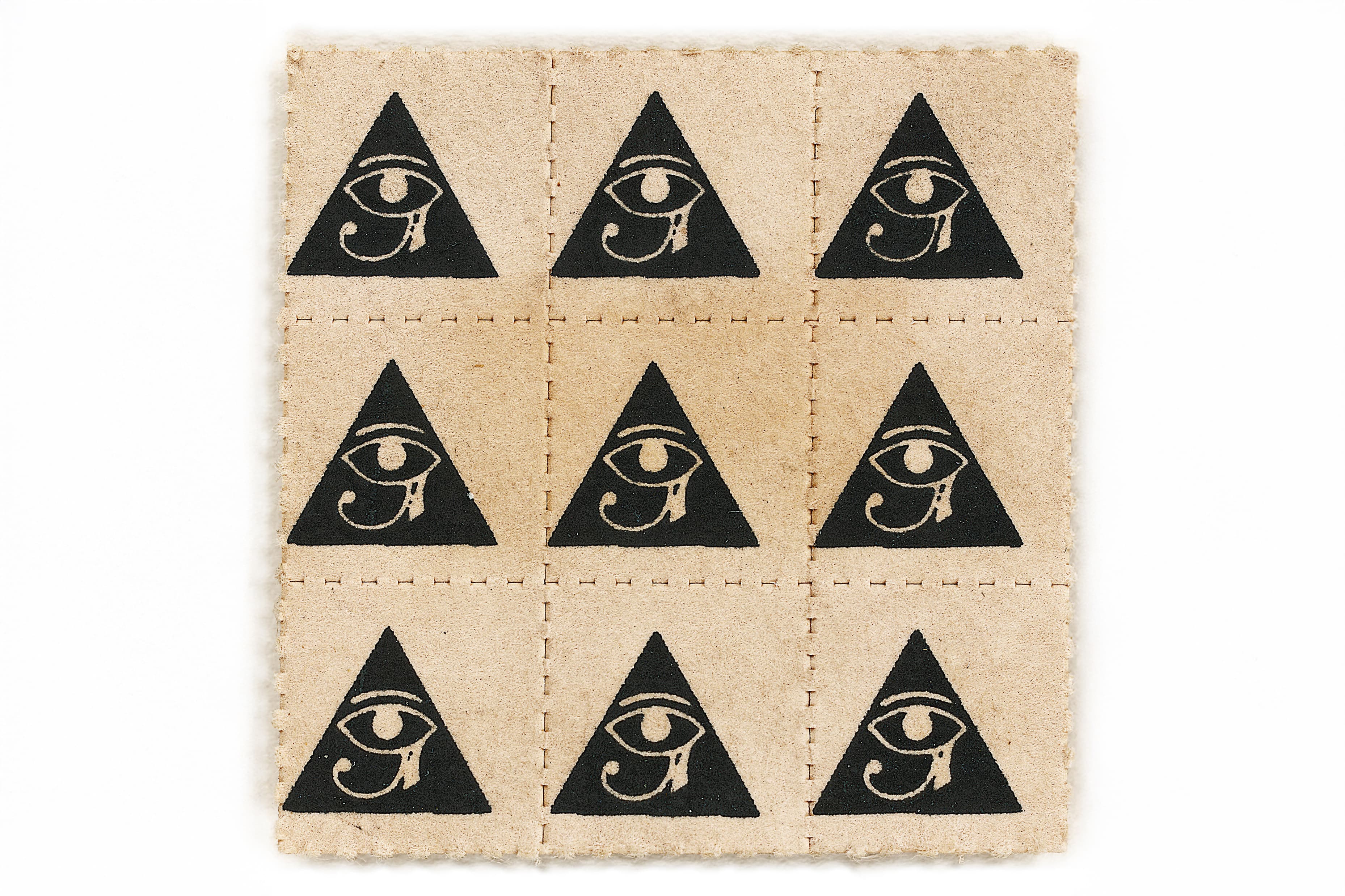 A square sheet of tan blotter paper divided by perforated lines into a nine-square grid. Each square features an identical black stamp of a triangle containing the Eye of Horus.