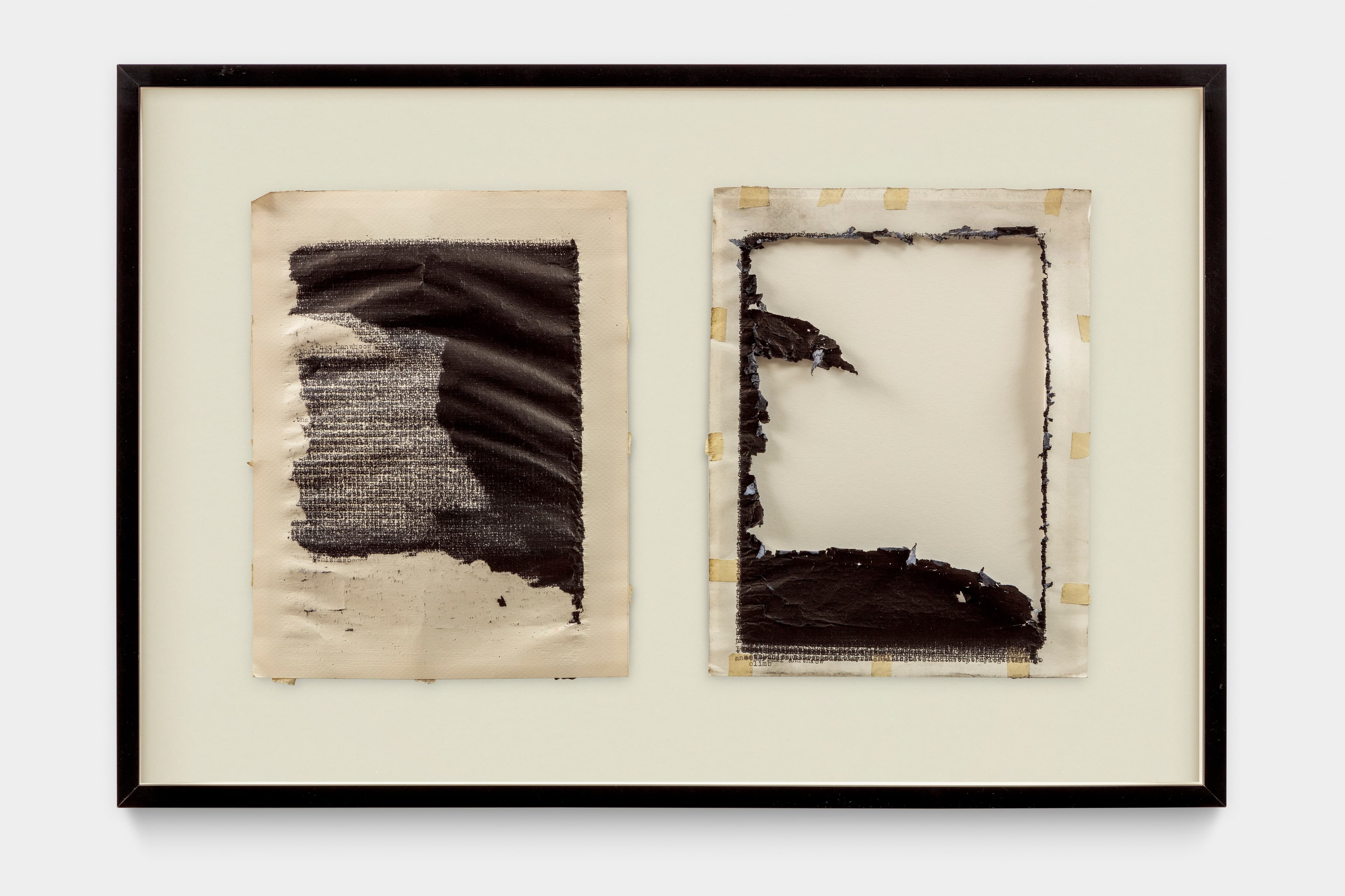 Two framed pieces of paper are displayed side-by-side. The left piece is off-white with a large, textured black painted area covering most of its surface, obscuring underlying text. The right piece is off-white with a rectangular cutout in its center, showing distressed edges and remnants of black paint and tape around its perimeter.