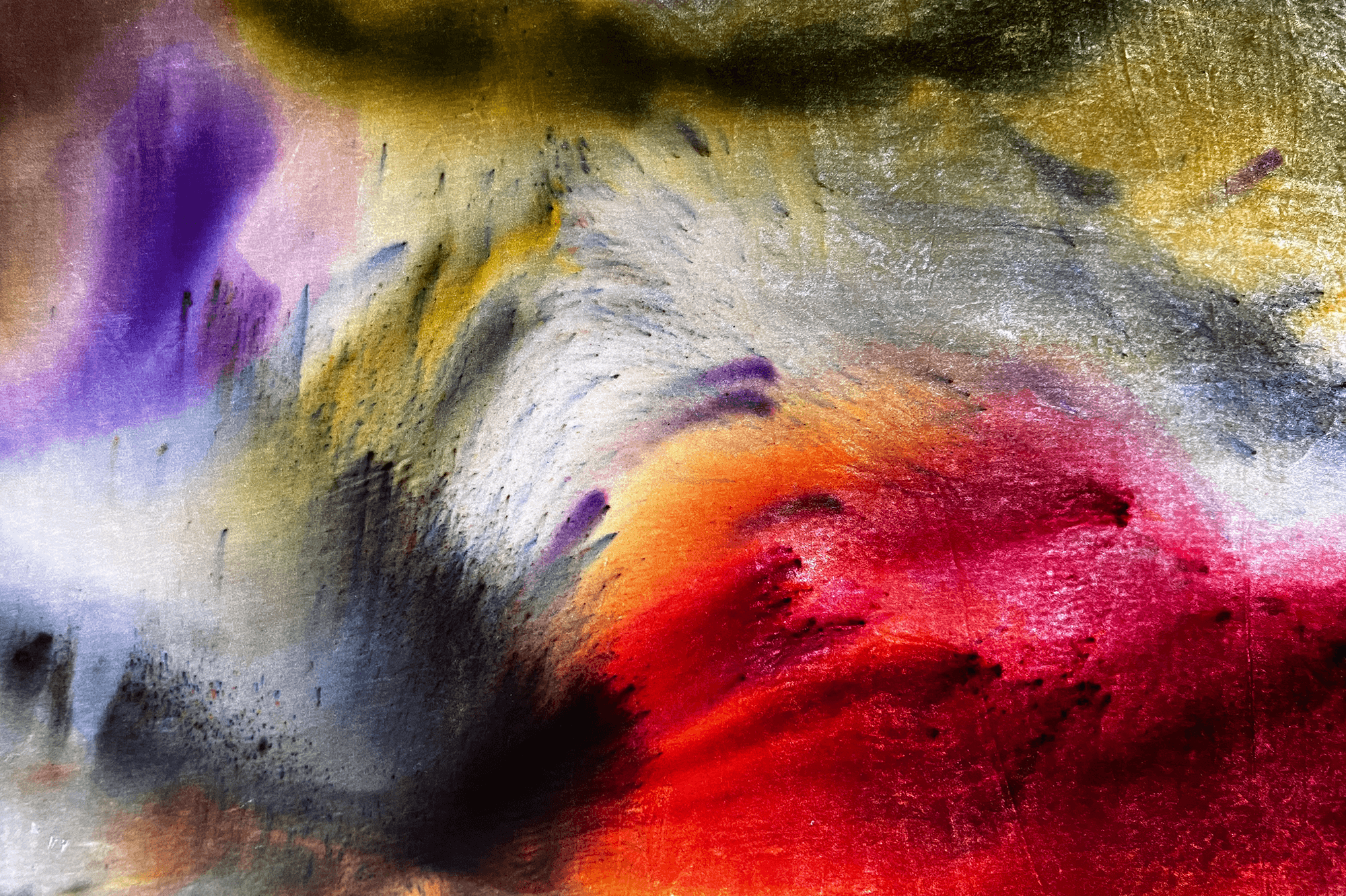 Close-up of dyed silk velvet with luminous washes of red, magenta, purple, gold, and pale blue blending across the fabric.