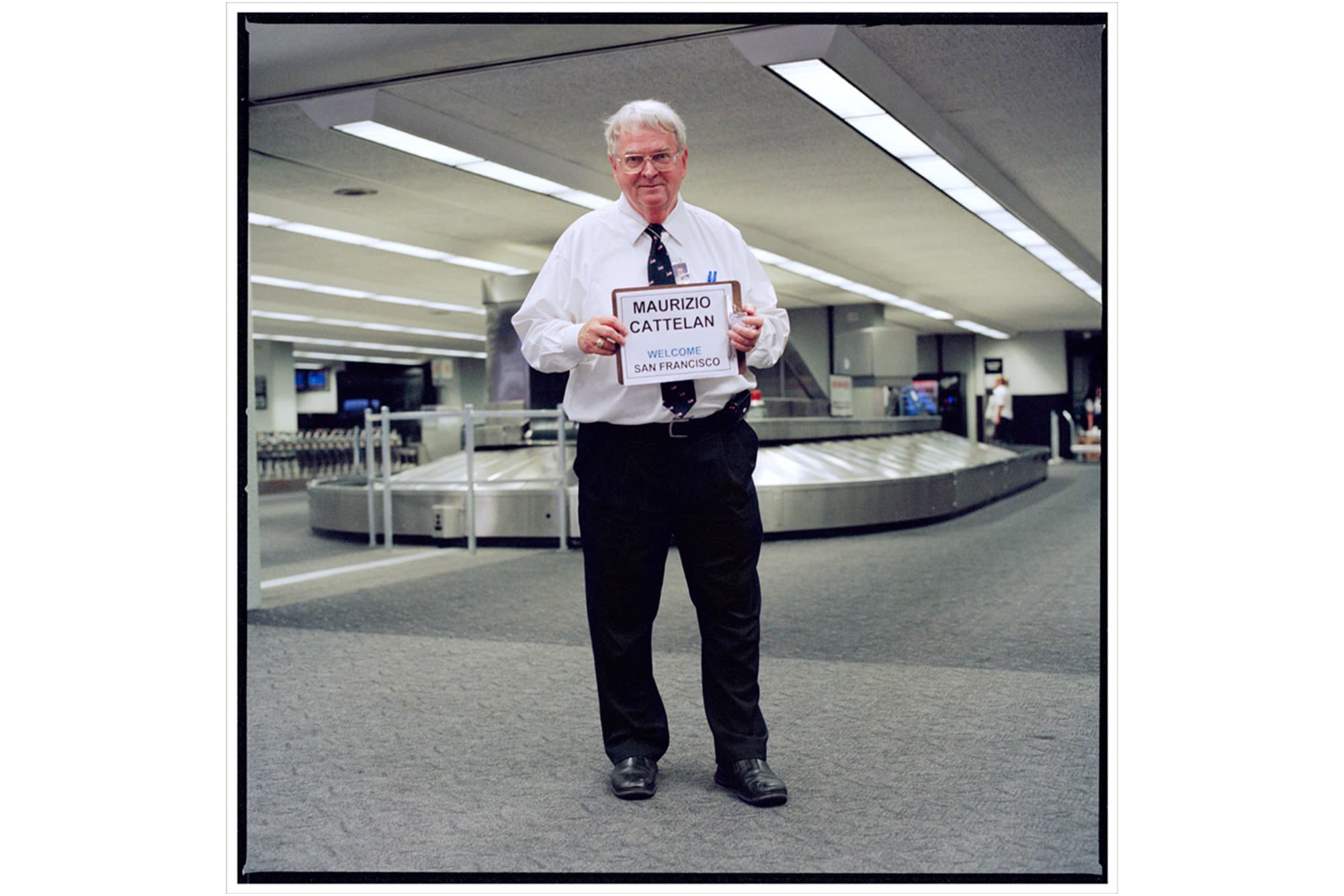 Driver holding up a sign _Maurizio Cattelan_ at an airport.